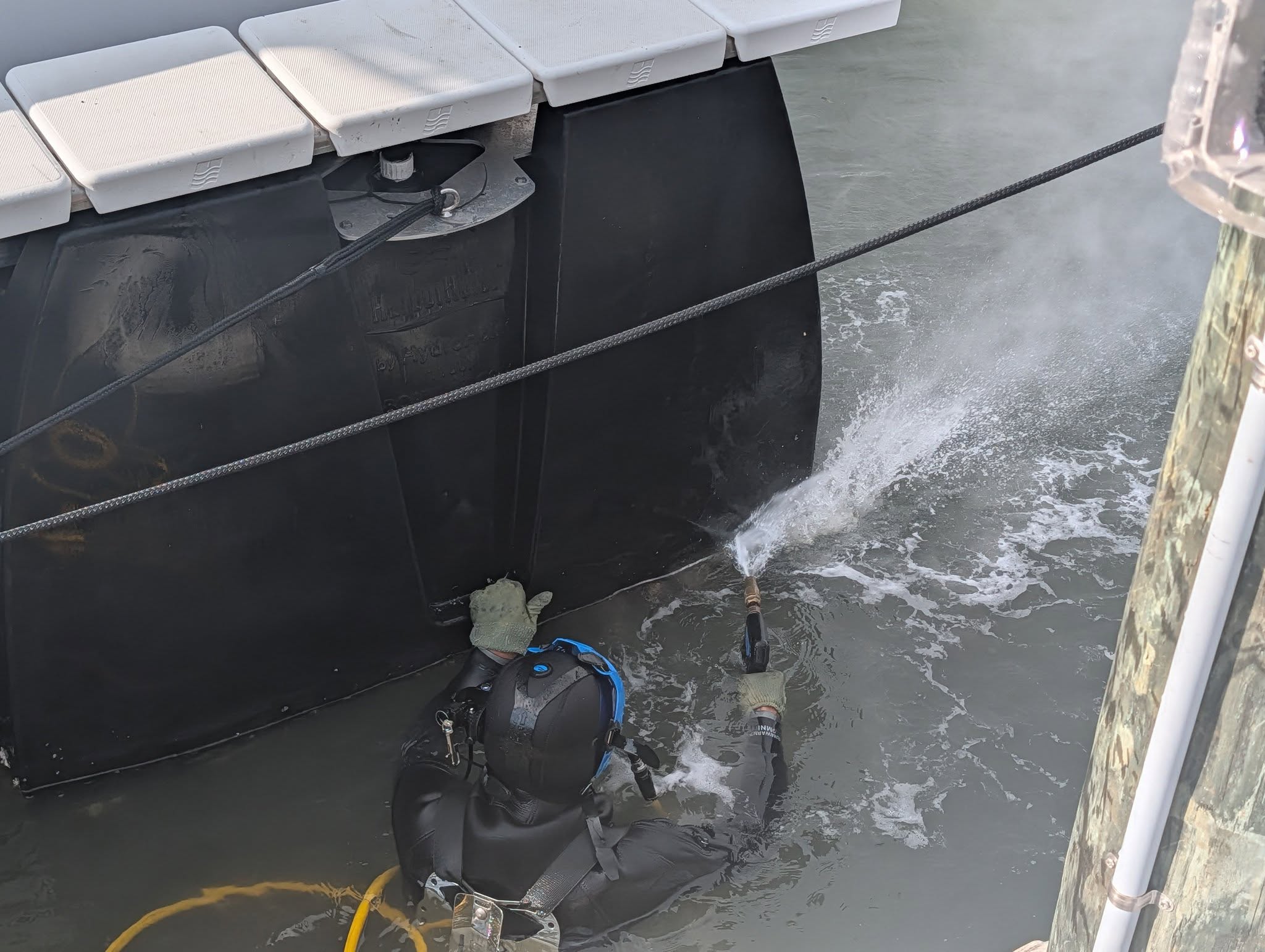 Diver pressure washing a floating hydrohoist dock