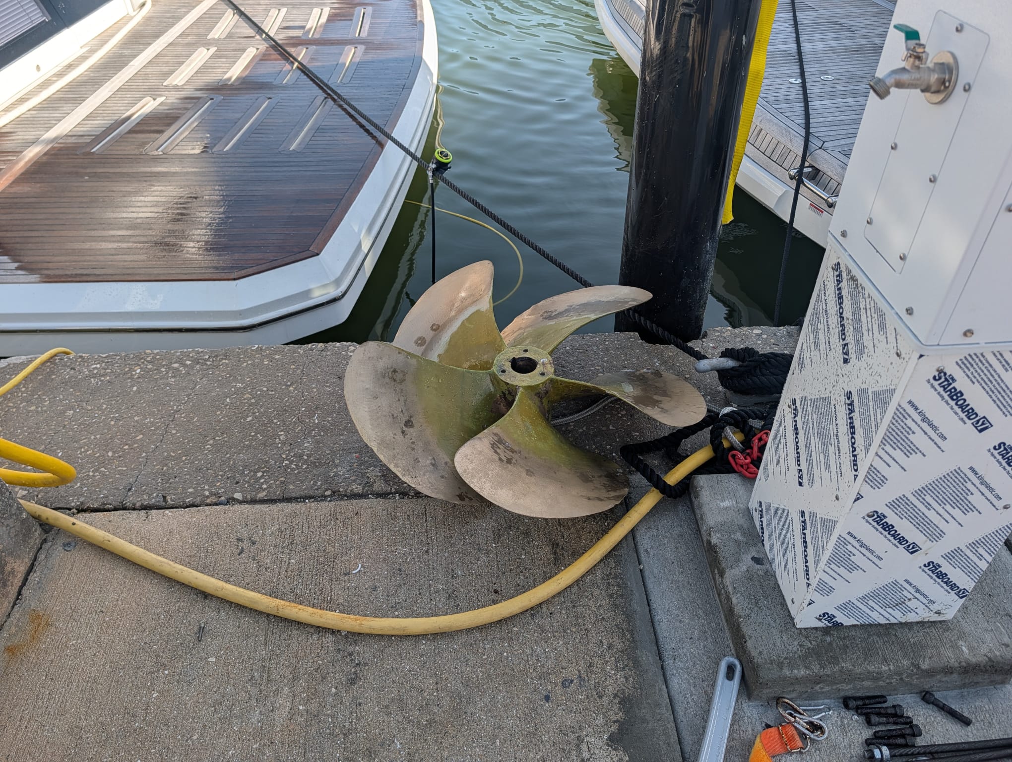 Large boat propeller beside a dock during service in Venice
