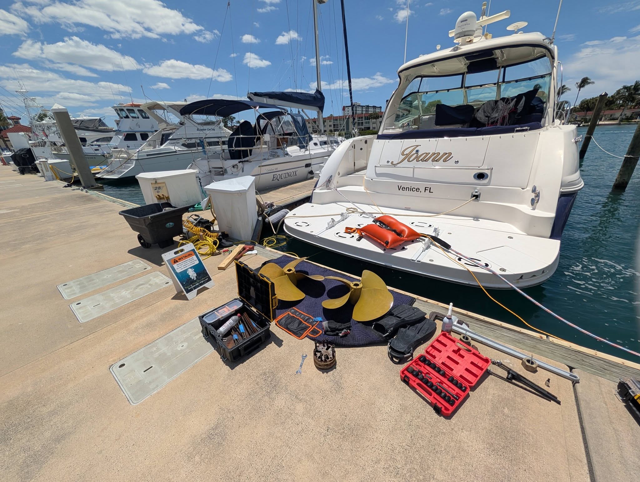 Propellers and dive equipment set up beside a yacht for a marina service job