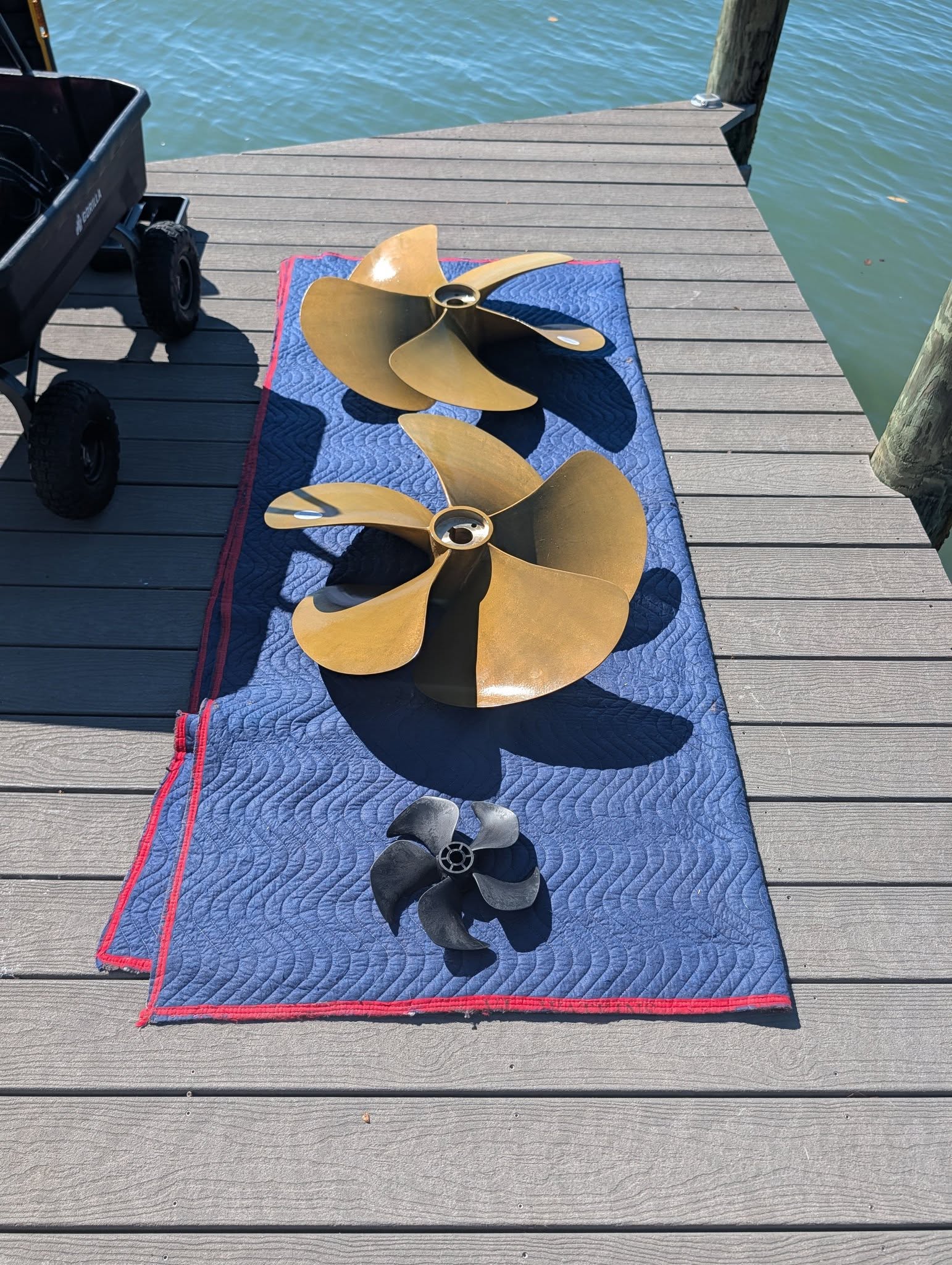Boat propellers and bow-thruster propeller laid out at a dock