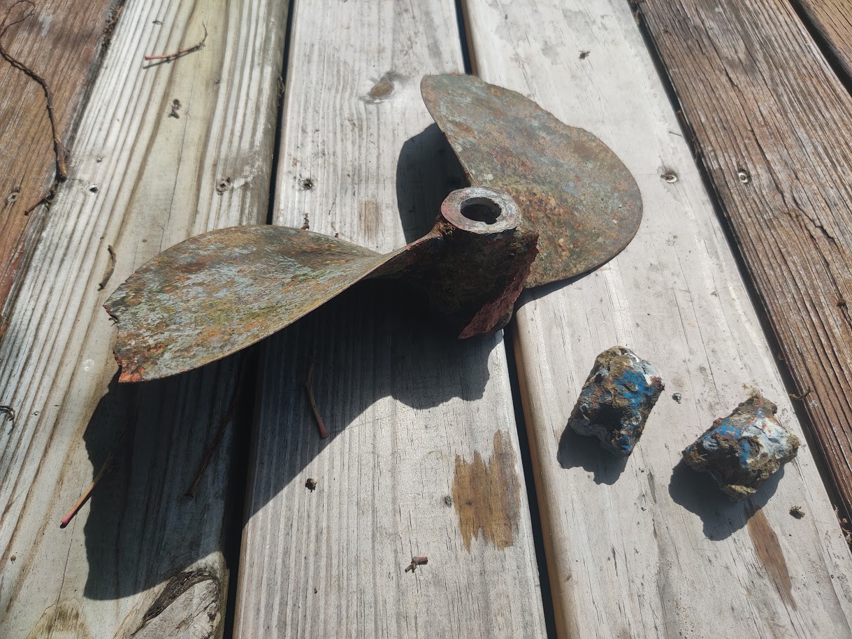 Removed propeller and corroded running-gear components on a dock